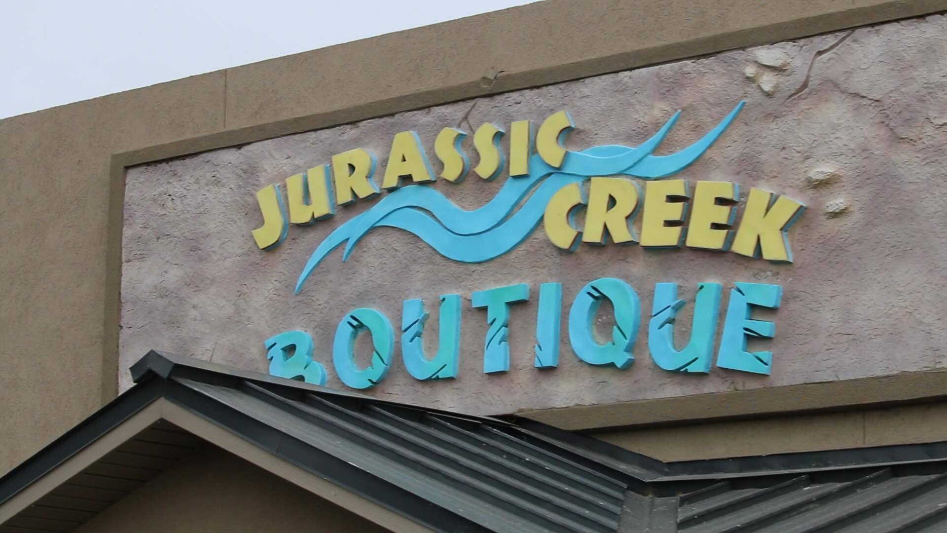 A sign on the front of a building that reads 'Jurassic Creek Boutique'