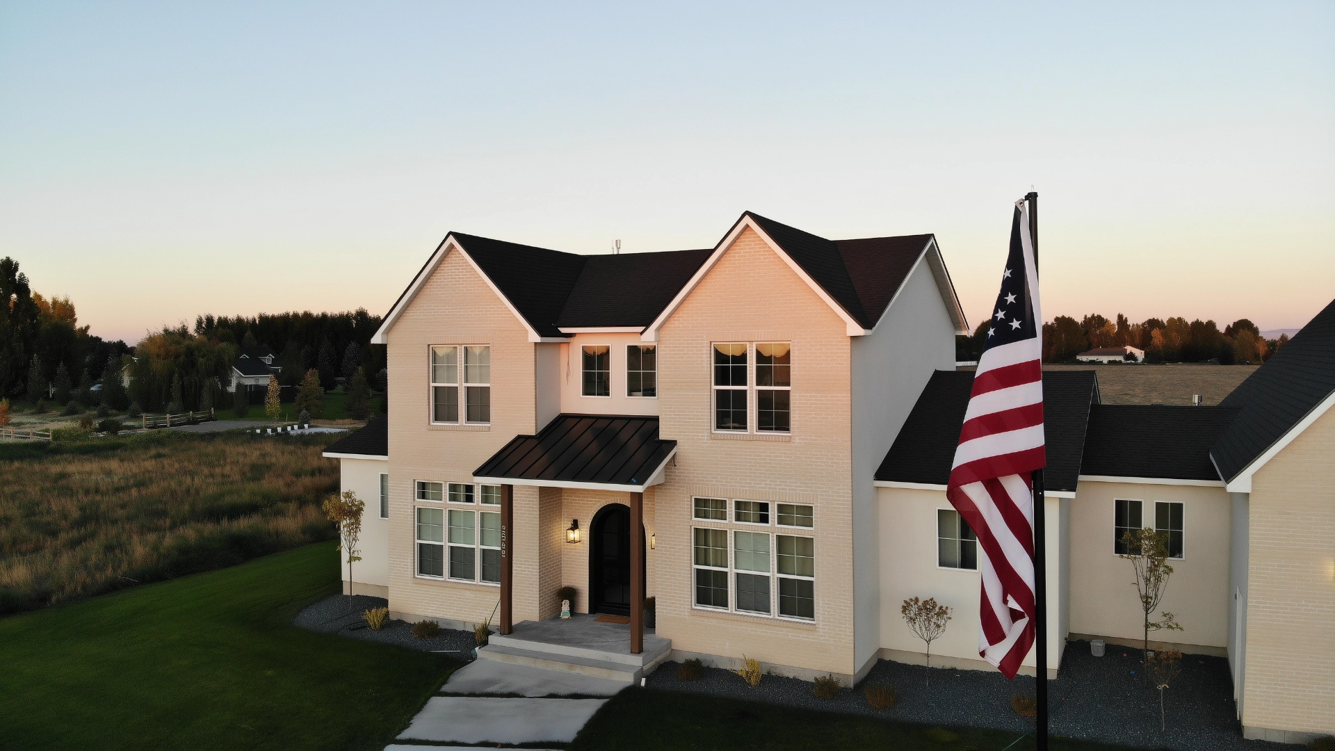 A two-story house with an American flag in the foreground